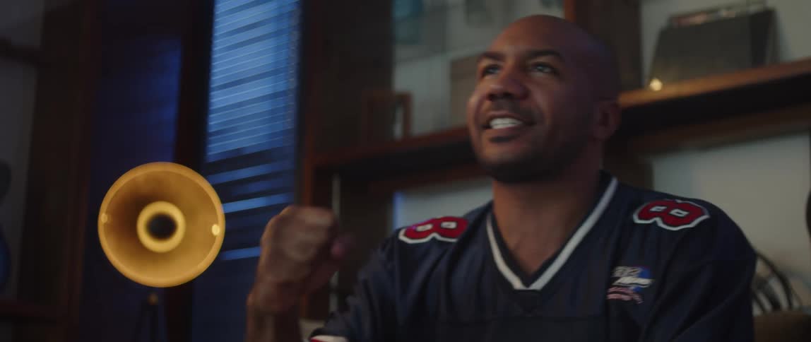 A man cheers while watching an event on tv at home