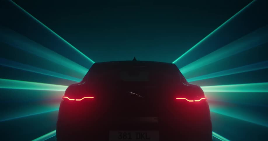 A car appears to be driving forward as beams of light streak past it