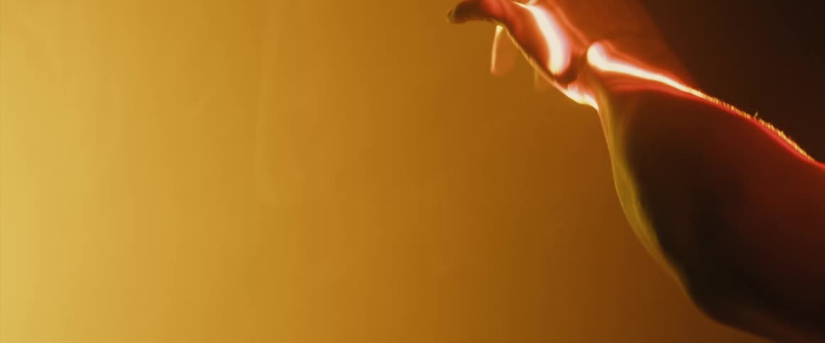 Person performs using their hands that are highlighted by light