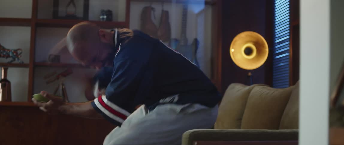 Young man sitting on a couch at home watching sports celebrates excitedly a good play