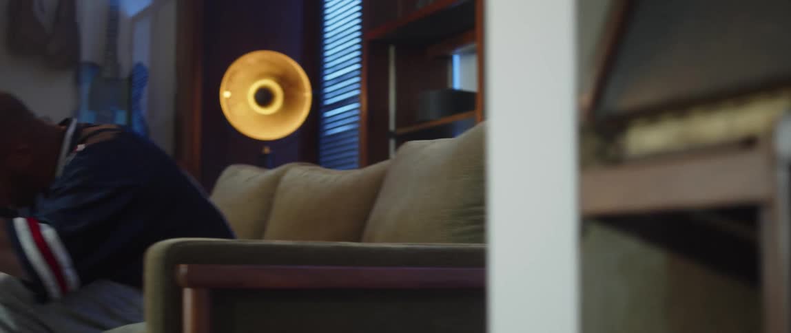 A man cheers while watching tv on the couch
