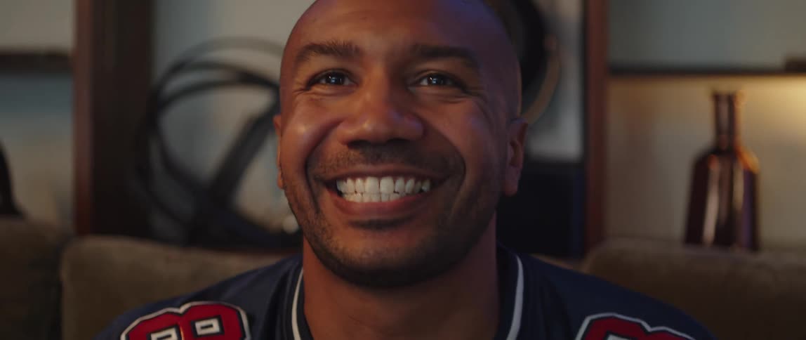 A man in a sports jersey cheering for his team on television