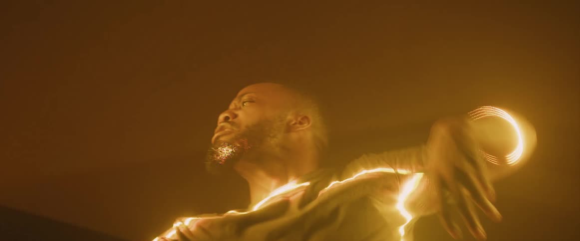 A man dances under the light