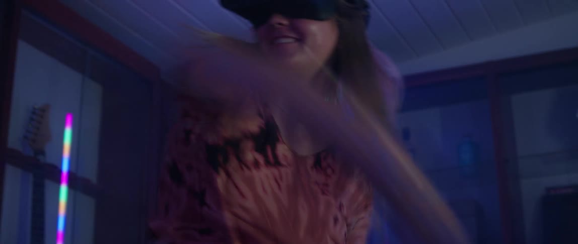 Couple wearing virtual reality goggles playing a tennis video game inside a futuristic looking room