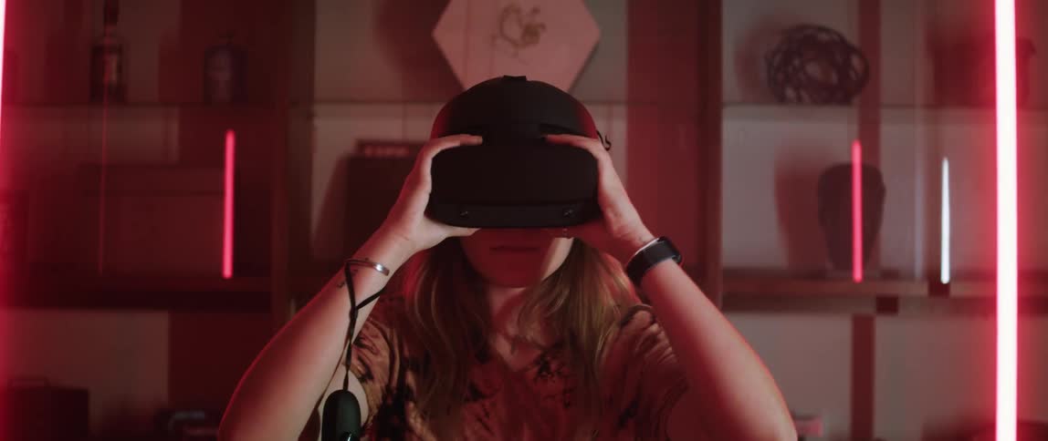 A teenage girl at home puts on a virtual reality headset