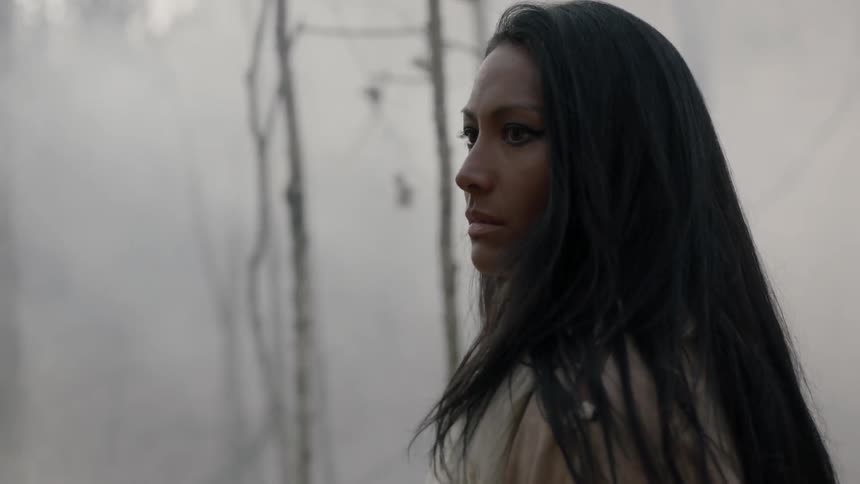 Tribal woman walking through a smoky forest
