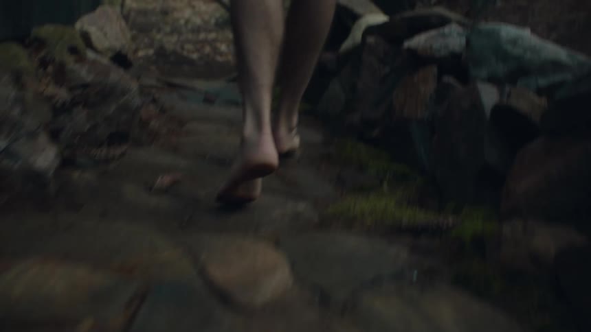 Man runs along stone steps and a paved path before entering open doorway