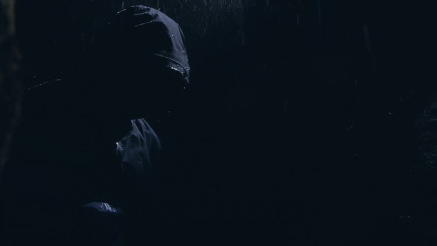 A man in a rain jacket standing outside during a rainstorm
