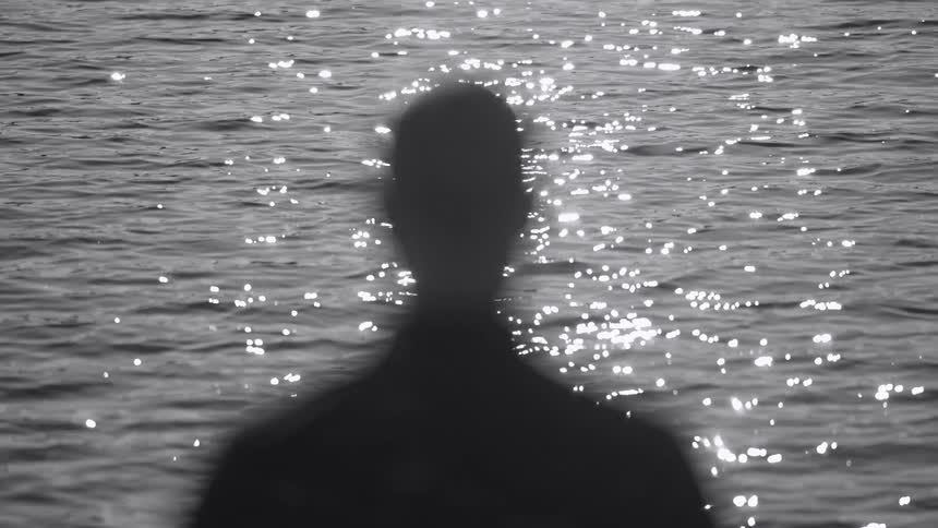 A person is walking towards the water