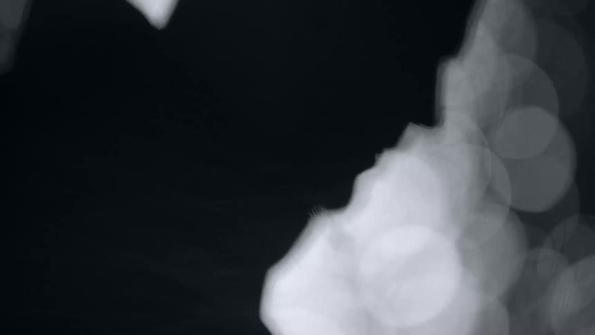 A man is standing with lights behind him causing a silhouette of his form