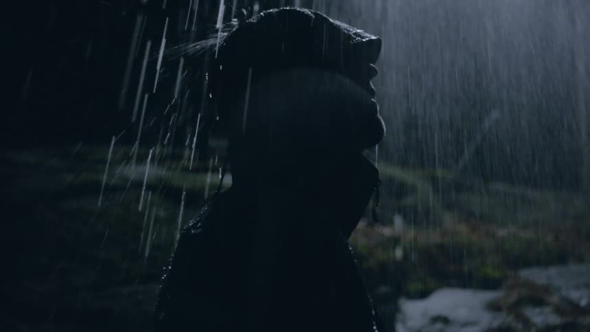 A man is standing in the pouring rain