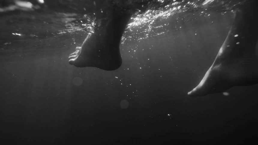 The feet of a woman kicking under water