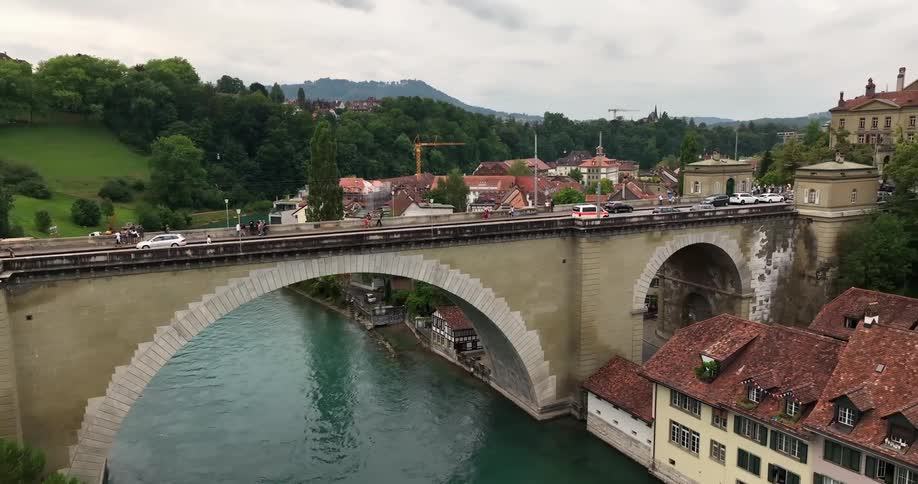 Cars driving over a river bridge in a small town