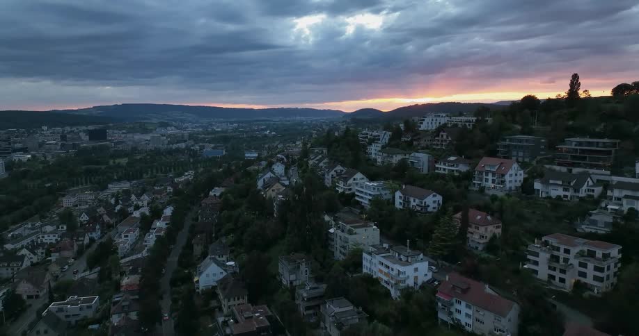 An aerial view of hillside homes on a cloudy evening