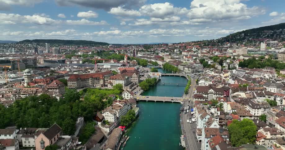 An aerial view of a small village is shown with several houses crammed together and a river going through the middle
