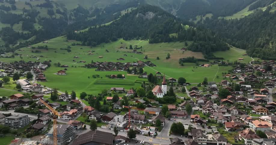 Heavy clouds hang over the mountain tops near a town