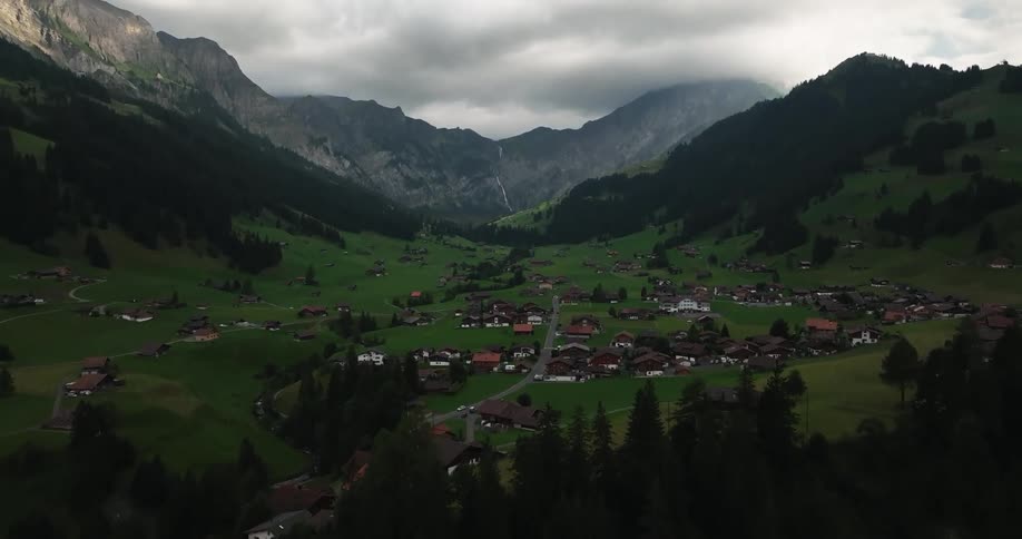 A neighborhood with houses in a mountain valley pasture during the day