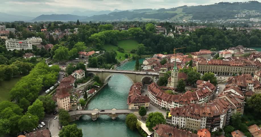 A town with a river and two bridges with human activity from an aerial view during the day