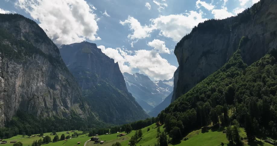 A small village is nestled between large mountains in a canyon