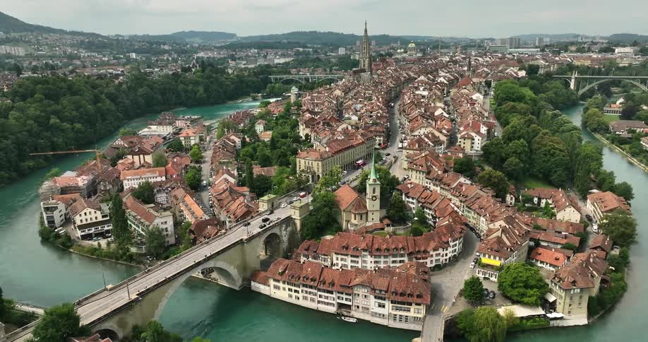 Aerial view of city buildings with roofs surrounded by river with bridges