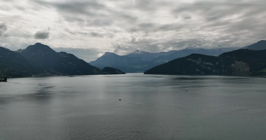 An aerial view of a large body of water is shown with mountains surrounding it