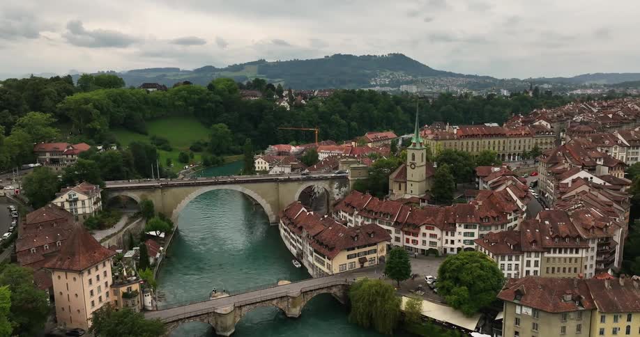 Arch bridges run over a river in a historical town