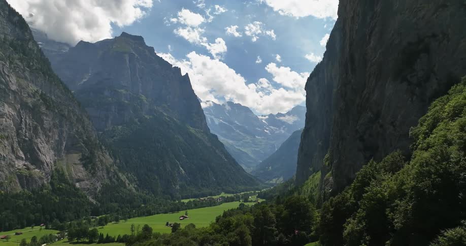 Homes sit far from each other in valley between mountains on foggy days