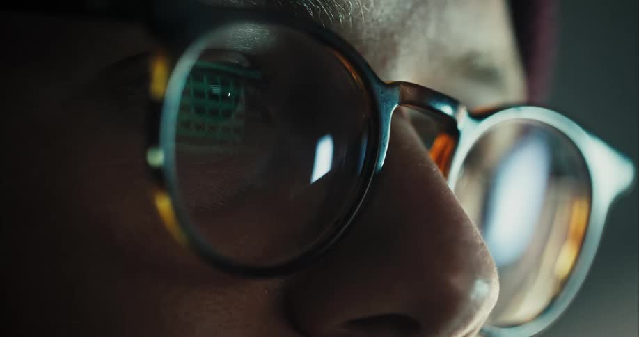 Light reflects on the glasses on a mans face