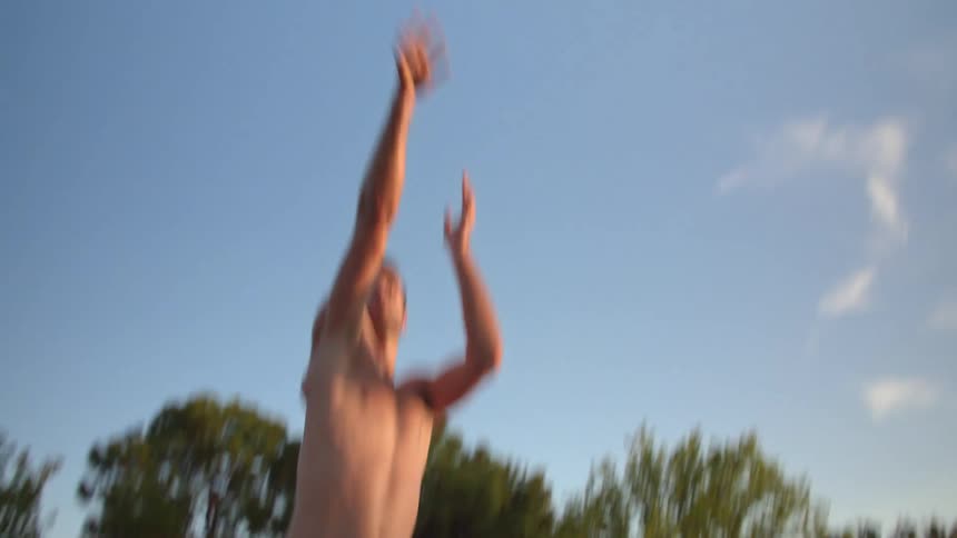 Topless man with black shorts plays basketball in the basketball court