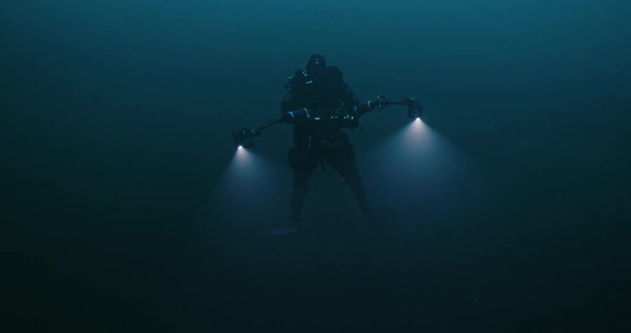 A person is scuba diving with cameras
