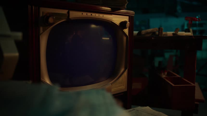 A vintage television turns on and plays static
