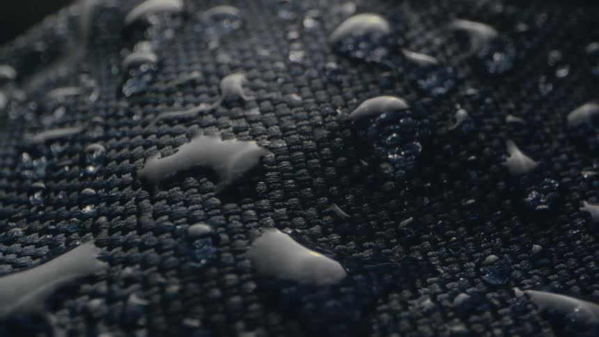 Rain is falling and making larger drops on a piece of fabric