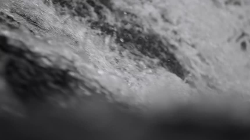 Light shines and reflects on water in the rapids splashing as it moves