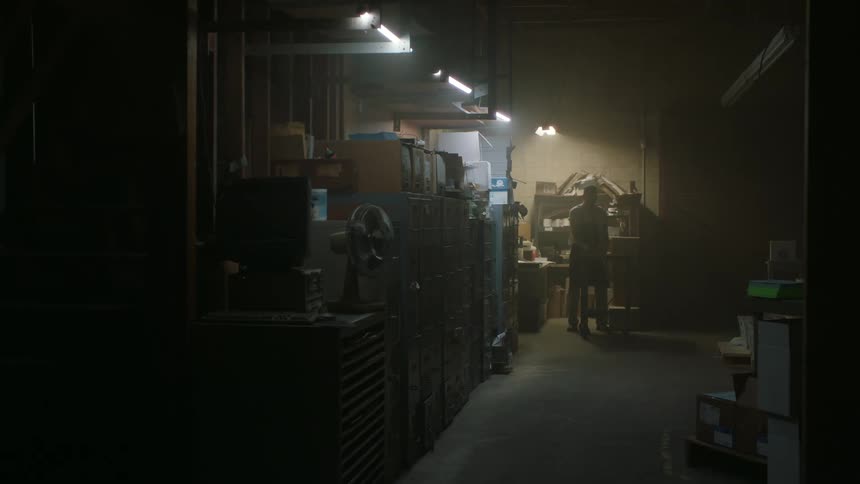 Man turns on the lights on a dimly lit garage and takes out a bicycle