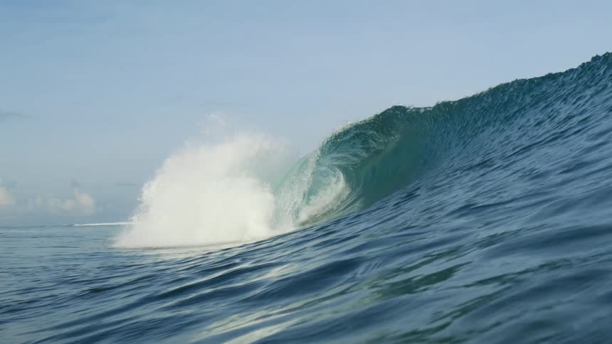 A large wave folding over in the ocean during the day