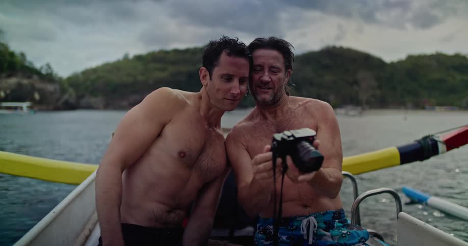 A man takes a picture of his friend in the boat