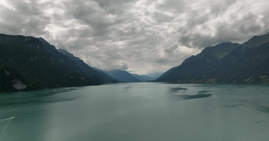 Overcast of clouds with a mountain range and a large lake during the day