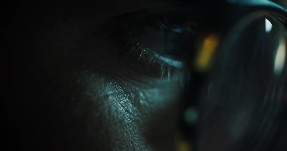 Close up of persons blue eye with glasses