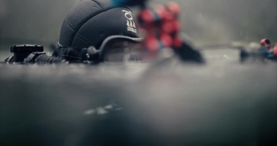 A scuba diver holding a camera recording footage in water