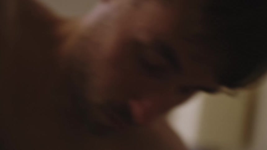 Man wakes up and wipes his face as he gets up
