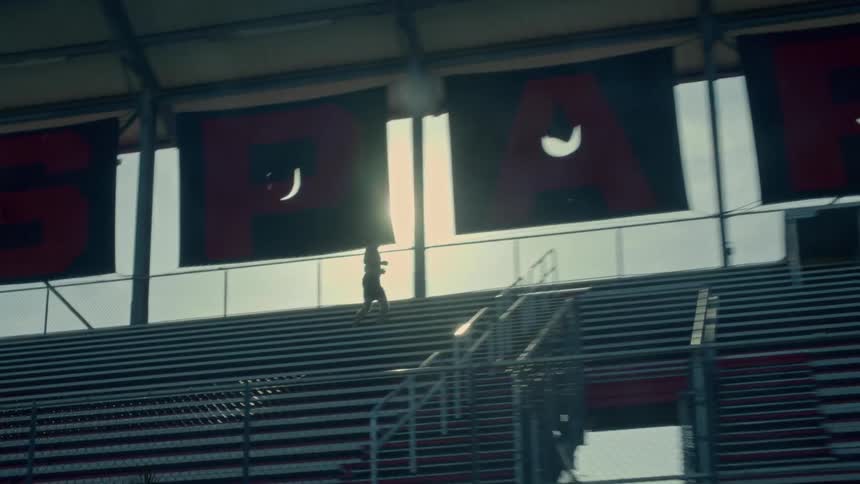 Male runner runs down bleachers as the sun shines brightly