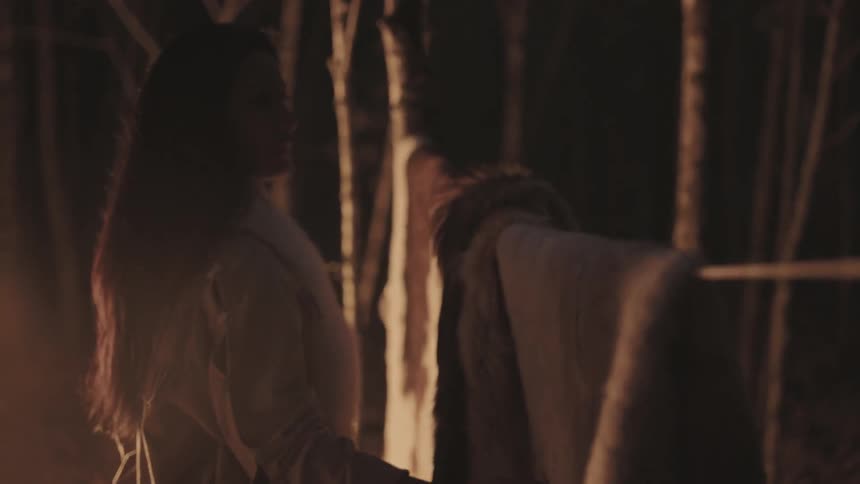Native woman hanging a hide on a rope with others