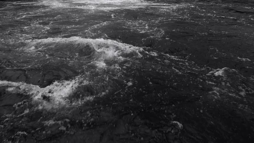 Light reflects on rough water as it splashes and waves as it moves