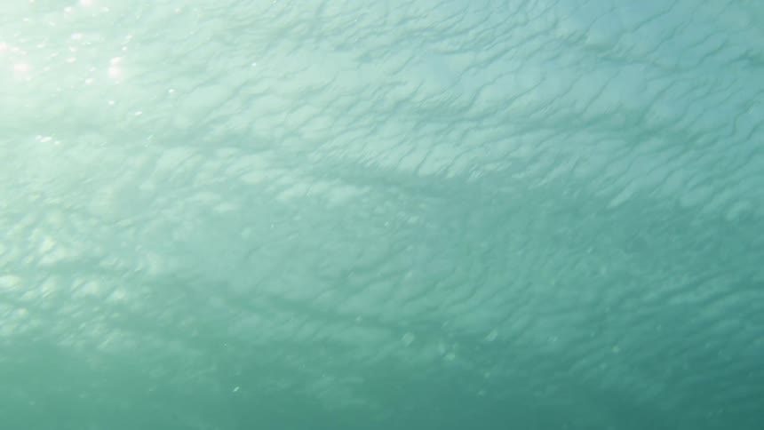 Underwater shot with a man standing underwater in the distance
