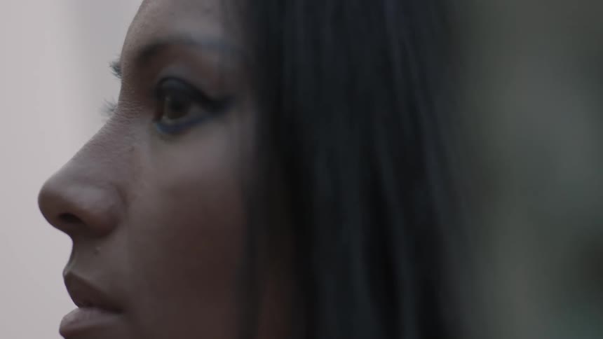 A dark haired woman looks around