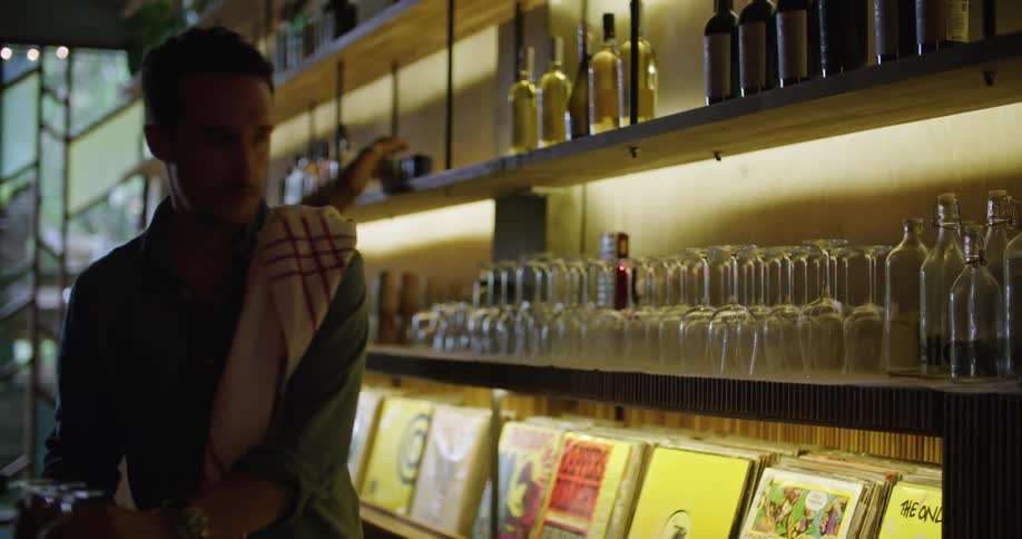 Bartenders place wine glasses on the shelf behind them