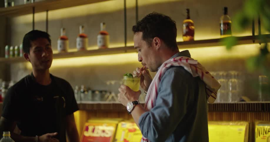 Two men celebrate a new drink recipe as they stand behind the bar
