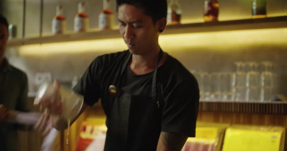 Bartender preparing a drink in front of the bar counter