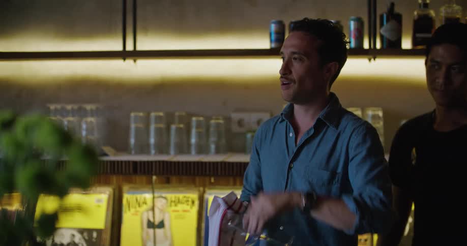 A man is cleaning a glass in the bar