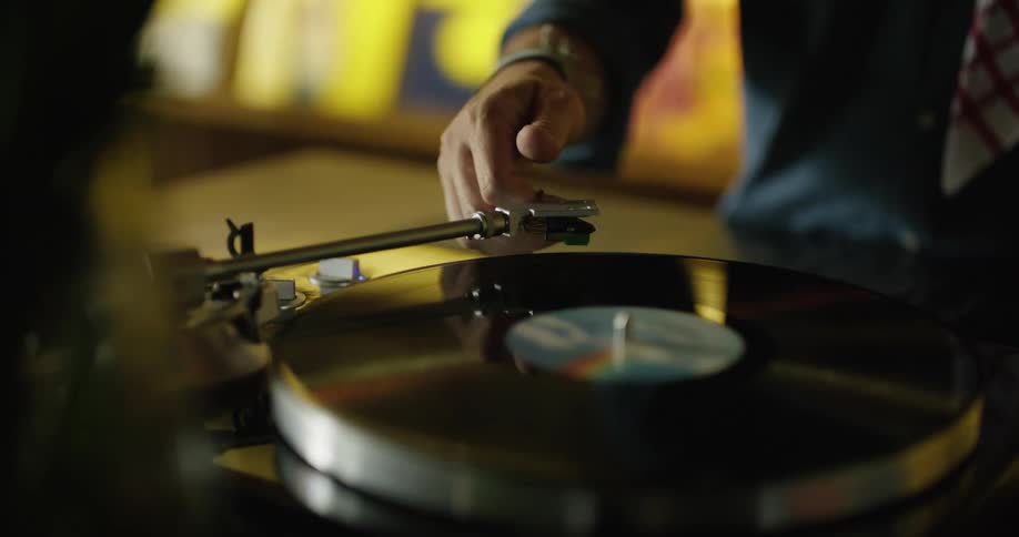 A deejay puts a vinyl album on a record player